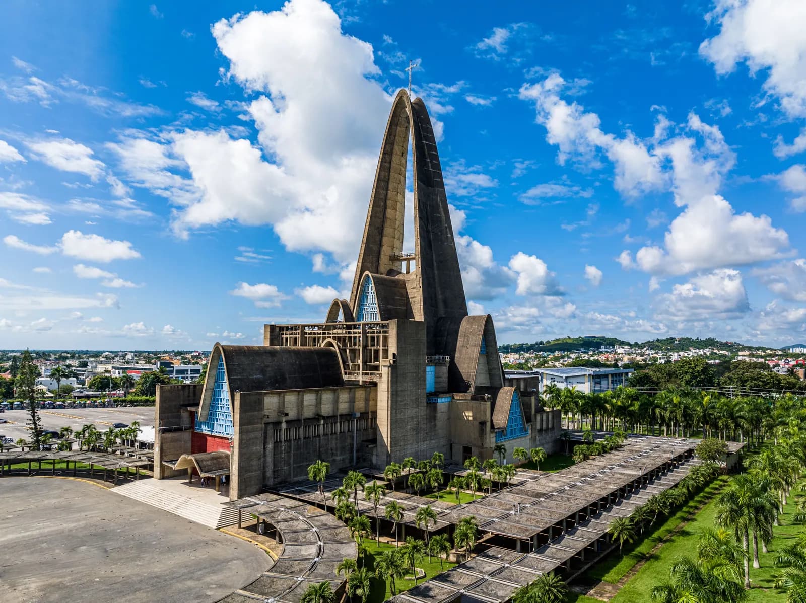 Basílica de Nuestra Señora de la Altagracia en Higüey, con su gran arco de concreto, palmeras y cielo azul
